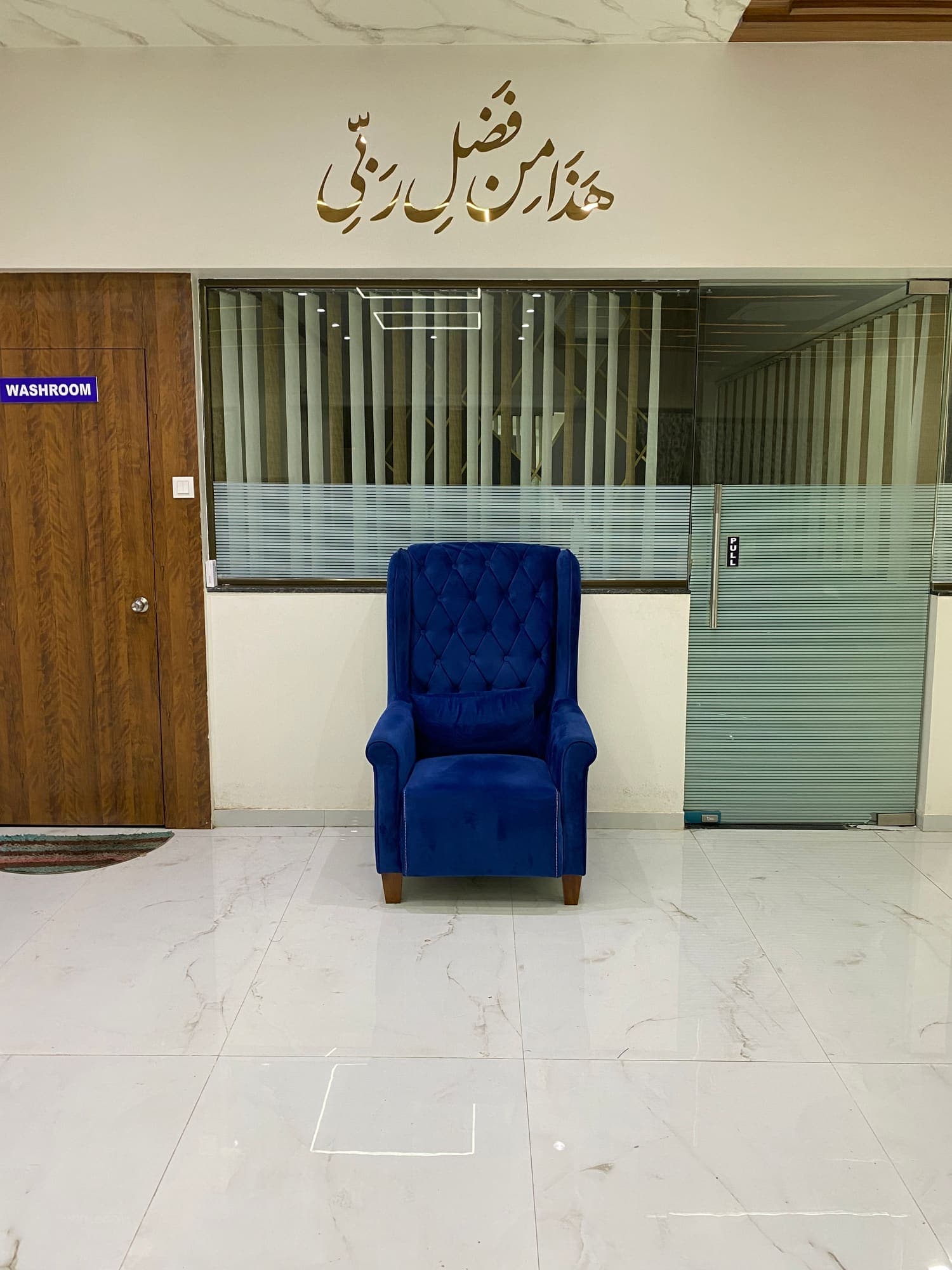 Reception with a blue armchair and glazed partition