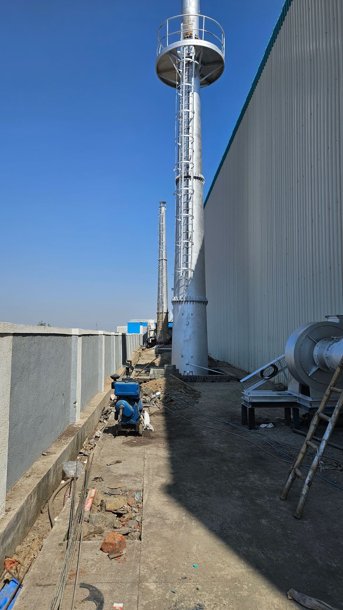 Exhaust stack beside the clad factory wall