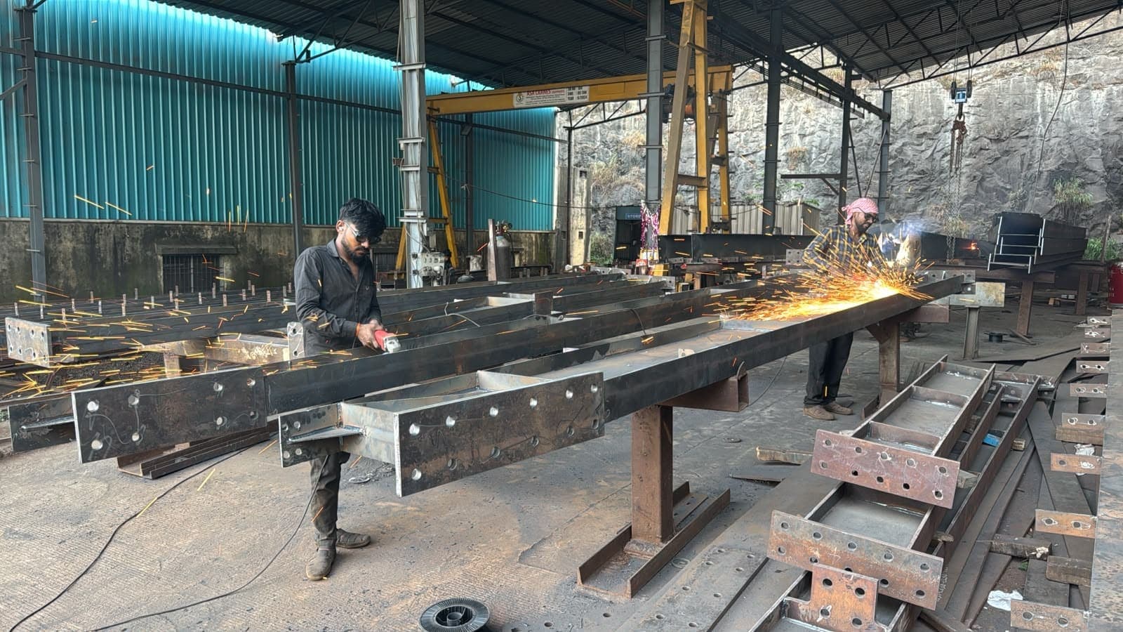 Fabricators grinding and welding built-up rafters in the fit-up bay